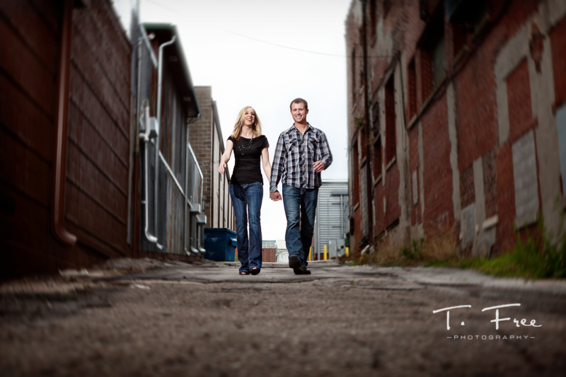 Couple natural action laughing alley photo taken on their engagement session in downtown Omaha.