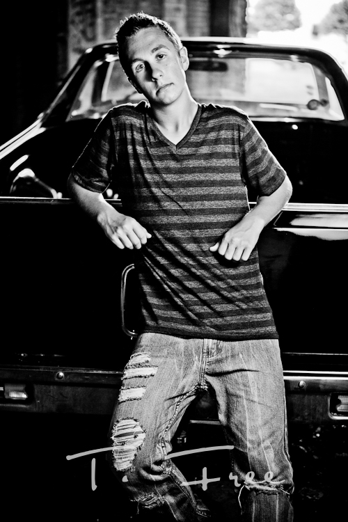 Popular Omaha high school senior black and white guy photo posing against his el camino car.