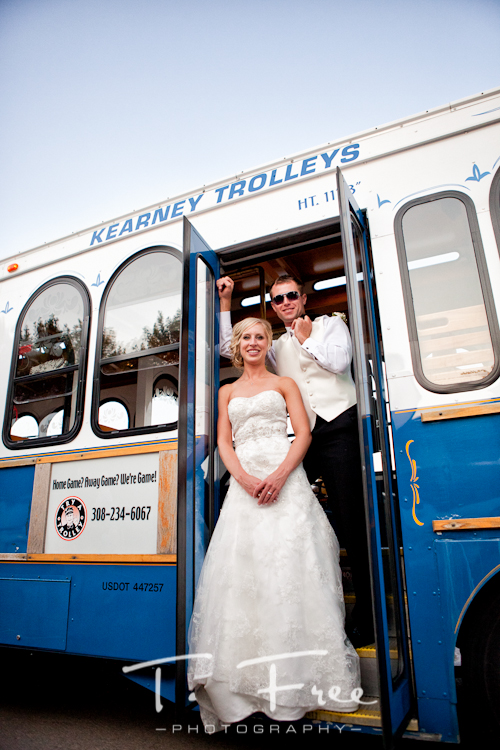 Bride and groom driving at their wedding reception on a Kearney Trolley in Holdrege Nebraska.