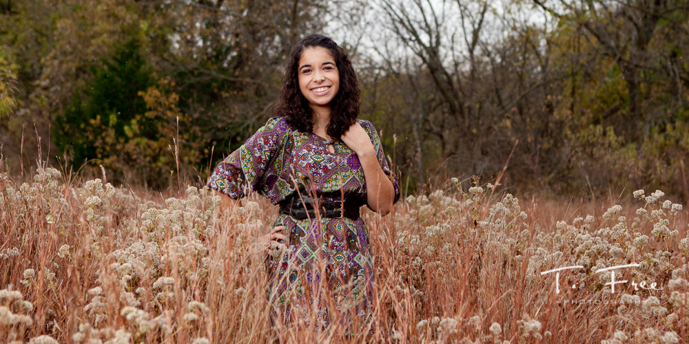 Stunning senior photo with a colorful dress and tall grass taken near Elkhorn, Nebraska.